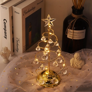 Close-up of golden spiral iron Christmas tree lamp with LED lights and crystal drops