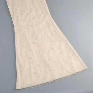 Close-up of beige tulle dress featuring delicate hand-sewn pearls and sequins detail
