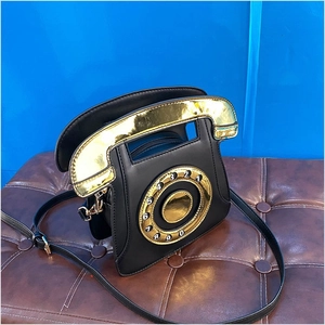 Detail of retro telephone crossbody bag in black PU leather with gold sequin dial decoration