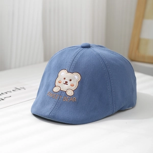 Gros plan d'un béret bleu pour bébé avec écusson d'ours et broderie Sweet Bear