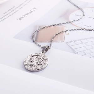 Detailed close-up of tree of life pendant with Greek fret pattern in silver finish