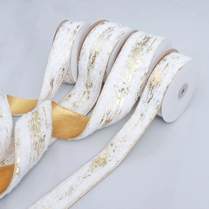 Macro detail of white plush ribbon with gold foil marbling and golden satin backing