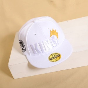 Dettaglio del ricamo King e corona arancione su cappello bianco a tesa piatta