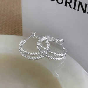 Silver geometric pleated layered hoop earrings with sparkling texture in a soft setting