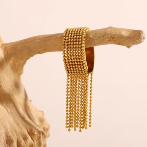 18K gold plated stainless steel beaded tassel open bangle displayed on a wooden branch