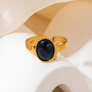 Detailed close-up of a vintage gold ring with an oval dark blue gemstone and hinge texture