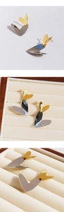 Detailed macro view of two-tone gold and silver heart-shaped earrings on velvet