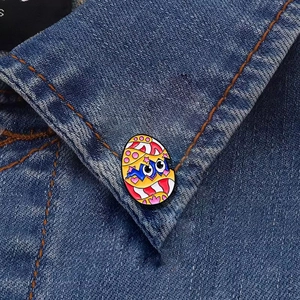 Cute dinosaur in eggshell metal enamel pin badge on blue denim shirt collar