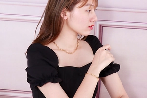 Detailed view of women's gold stainless steel chain necklace and matching bracelet set