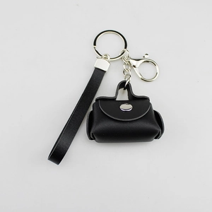 Detail of a black PU leather mini bag keychain with a sturdy metal clasp and strap.