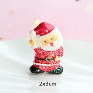Macro shot of 2x3cm Santa Claus resin accessory with festive red and white glitter details