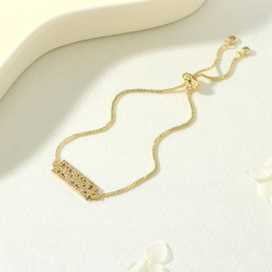 Macro detail of gold-tone MAMA zircon bracelet with adjustable box chain for Mother's Day