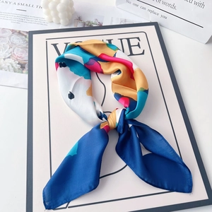 Detail of colorful abstract print satin scarf knotted on a fashion magazine