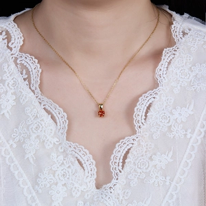 Detail of 925 sterling silver gold necklace featuring a round orange zircon pendant