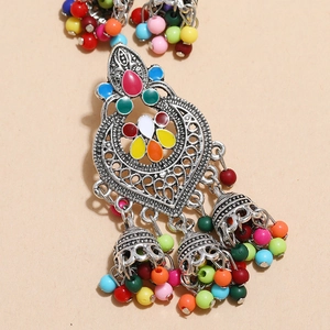 Detailed close-up of a silver ethnic Jhumka earring with colorful enamel and beads