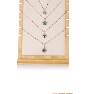Detail of colorful gemstone pendants on a bamboo wooden necklace display stand