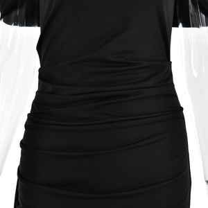 Détail d'une robe moulante noire avec des plis élégants à la taille et tissu extensible