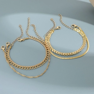 Detail of bohemian gold multi-layered chain bracelets featuring snake and cable links
