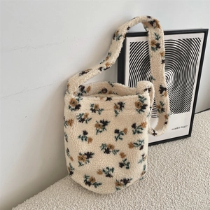 Detail of floral lamb wool bucket bag showing magnetic closure and soft plush texture