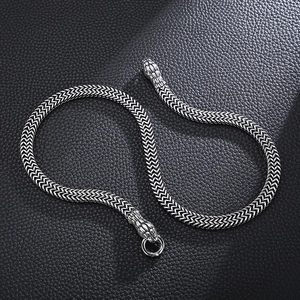 Detailed close-up of a silver stainless steel snake bone chain with snake head clasp