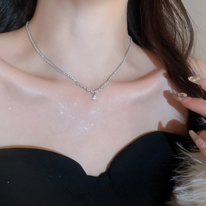 Close-up of silver zircon water drop pendant necklace set on a model for elegant look