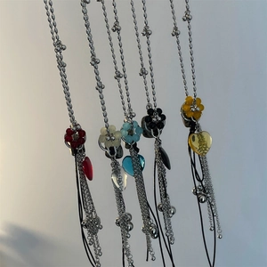 Close-up of five colorful Y2K heart pendants with metal bead chains and black tassels