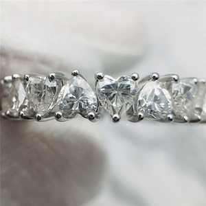 Macro detail of heart-shaped zircon stones set in a silver-tone prong wedding ring
