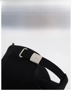Close-up of black cotton twill baseball cap with adjustable silver metal buckle and engraving
