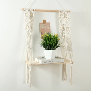 Detail of hand-woven macrame wall shelf featuring natural wood beads and cotton rope