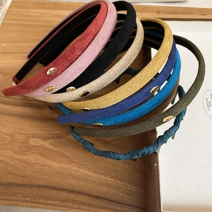 Détail de serre-têtes en velours coloré avec ornement métallique Love en gros plan