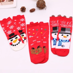 Detailed view of red Christmas cotton socks with knitted snowman and reindeer patterns
