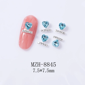 Detailed view of 7.5x7.5mm blue heart nail gem with silver setting on pink manicure