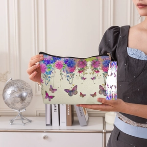 Trousse à maquillage en toile aux motifs floraux et papillons, tenue à la main
