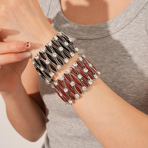 Dettaglio del set di bracciali vintage con pietre in resina bordeaux e nere indossato al polso