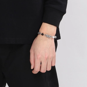 Detail of titanium steel chain bracelet with black and white pearls on model's wrist