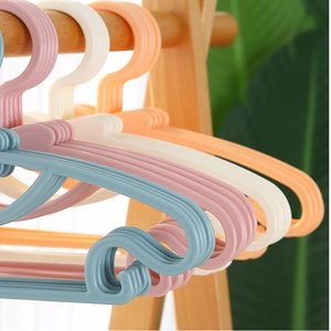 Kids plastic hangers set in macaron colors hanging on a wooden rack with bow detail