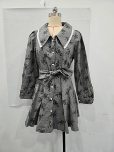 Détail de robe grise fleurie avec col en dentelle blanche et ceinture de décoration