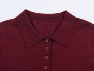 Détail du col polo en tricot bordeaux et de la patte de boutonnage à quatre boutons