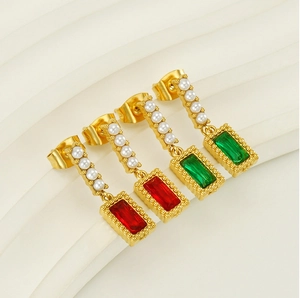 Detailed view of vintage gold earrings with red and green gems and mini pearls