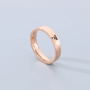 Macro shot of rose gold hammered texture titanium steel ring with unique metal reflections