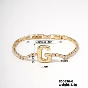 Detailed view of gold tennis bracelet with zircon letter G charm and size measurements