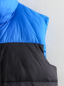 Vue détaillée des coutures contrastées et de l'épaule de la veste matelassée bleue et noire