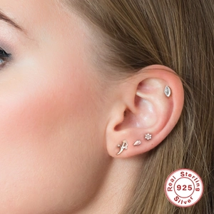 Detailed close-up of S925 sterling silver geometric stud earring set on female ear cartilage