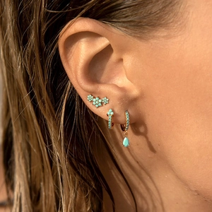 Luxurious 18k gold plated drop earrings set with turquoise stones worn by model