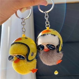 Detailed macro of plush duck keychains with yellow safety helmets and sunglasses