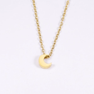 Gros plan du pendentif croissant de lune doré sur une chaîne fine au fini miroir poli