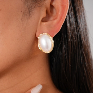 Boucles d'oreilles ovales dorées avec grande perle blanche et bordure texturée ondulée