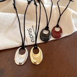 Colliers à pendentifs ovales minimalistes en argent, or, noir et bordeaux sur bois