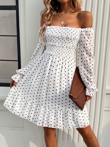 Detailed view of the off-shoulder white polka dot dress with smocked chest and ruffled trim