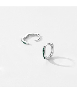 Detailed view of silver hoop earrings featuring rectangular green zircon stone settings